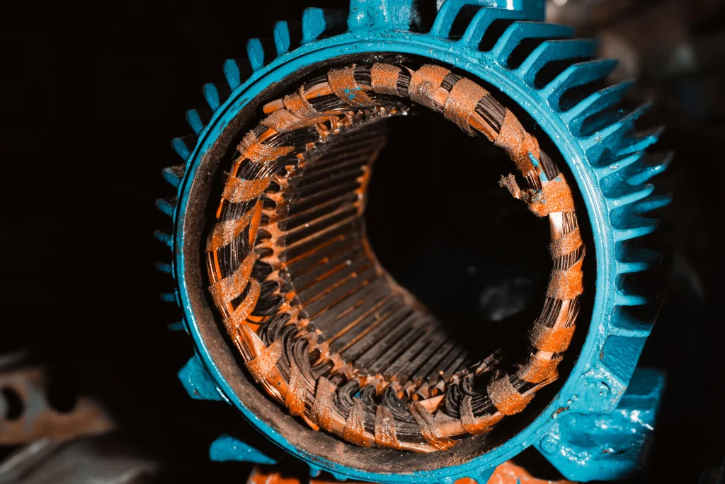 Primer plano de bobinas de cobre quemadas dentro de un motor, requiriendo un trabajo de embobinado de motores profesional.